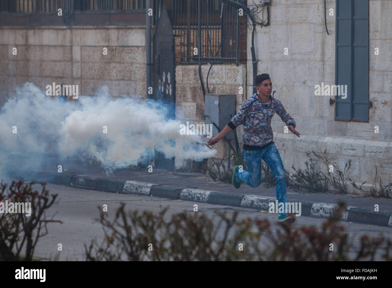 Betlemme. 29 gen, 2016. Un manifestante palestinese scaglia torna a gas lacrimogeni barattolo sparato dai soldati israeliani durante scontri in Cisgiordania città di Betlemme, il 29 gennaio, 2016. © Luay Sababa/Xinhua/Alamy Live News Foto Stock