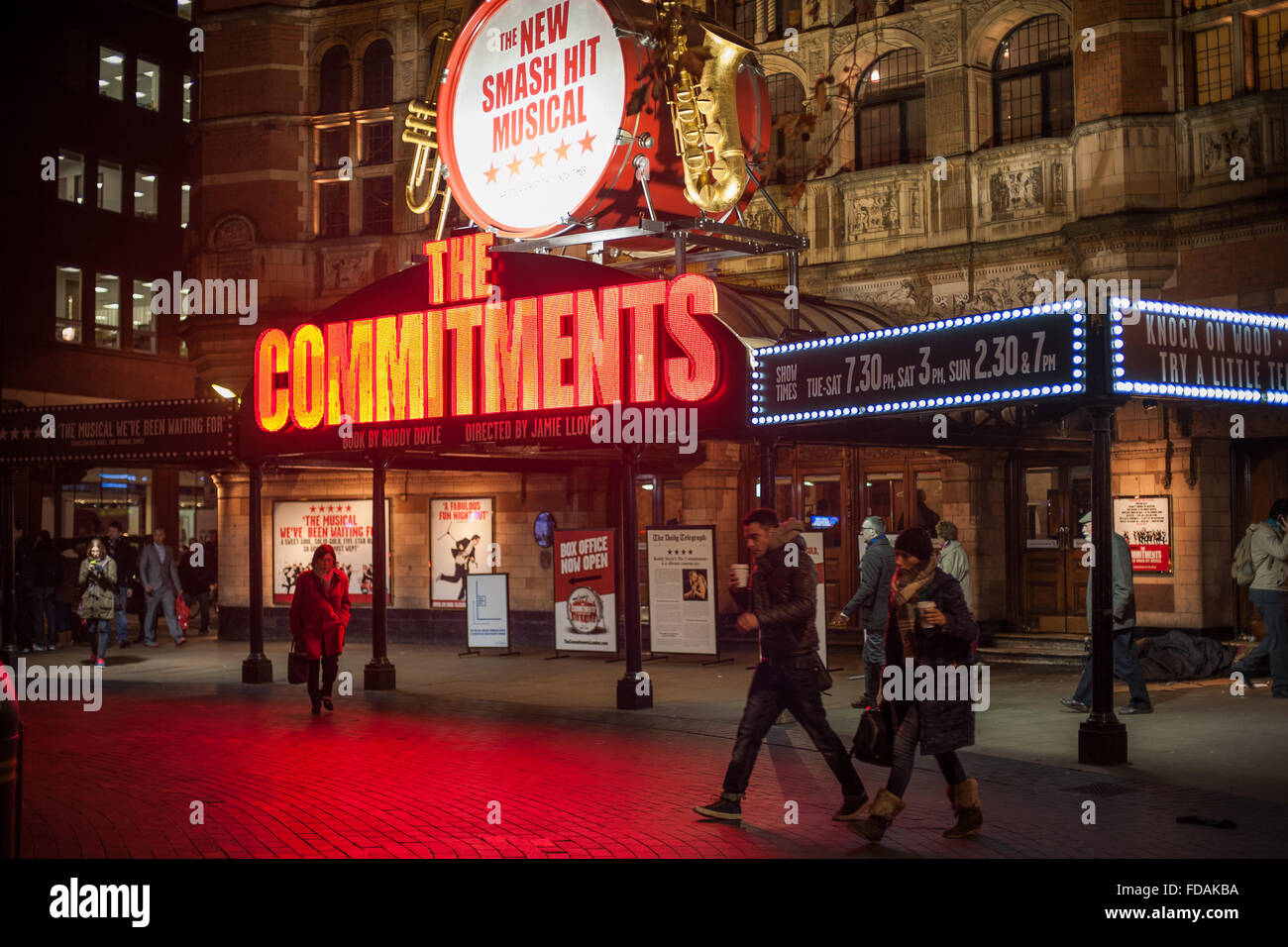 Pedoni sotto le luci al neon di "impegni" musical a Soho, Londra Foto Stock