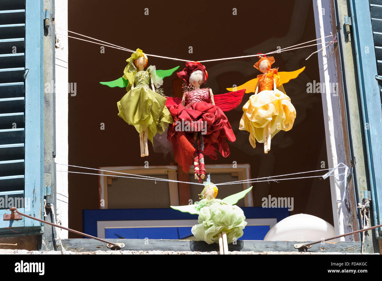Piccolo colorato bambole femmina appeso su una stringa al di fuori di una finestra nella Città Vecchia, Dubrovnik, Croazia. Foto Stock
