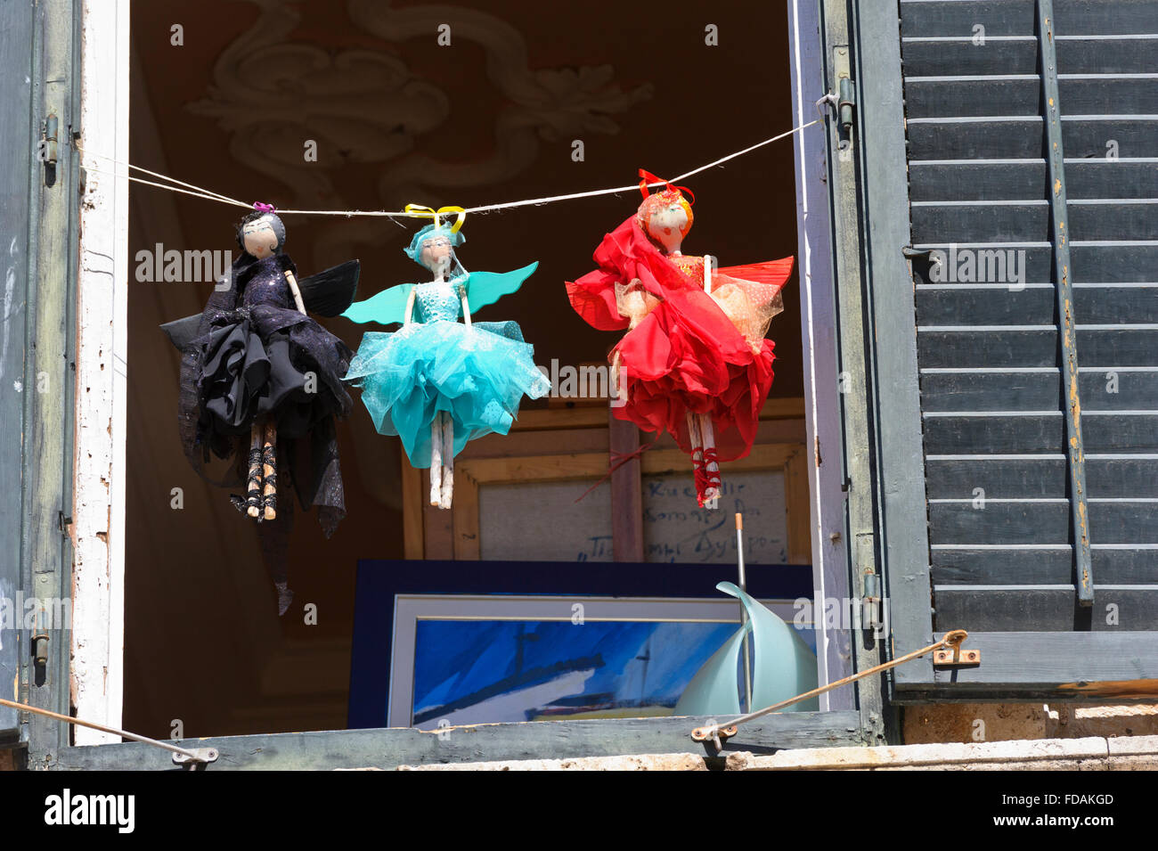 Piccolo colorato bambole femmina appeso su una stringa al di fuori di una finestra nella Città Vecchia, Dubrovnik, Croazia. Foto Stock