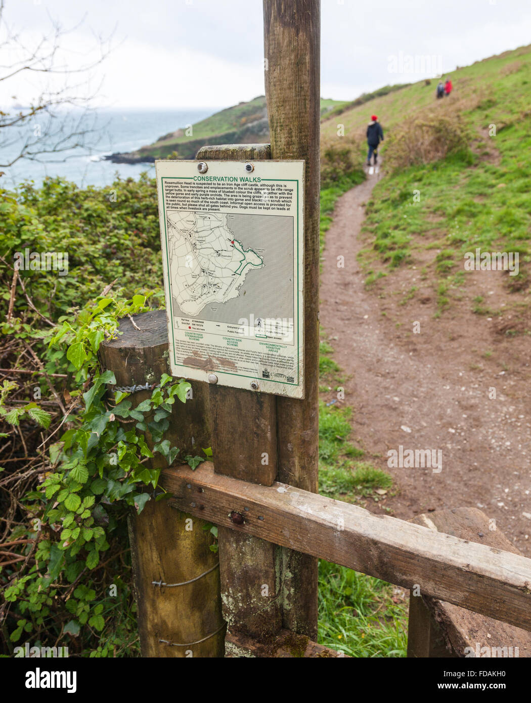 Un avviso o cartello per una conservazione a piedi intorno a testa Rosemullion Cornwall Inghilterra UK con il Walkers sul sentiero costiero Foto Stock