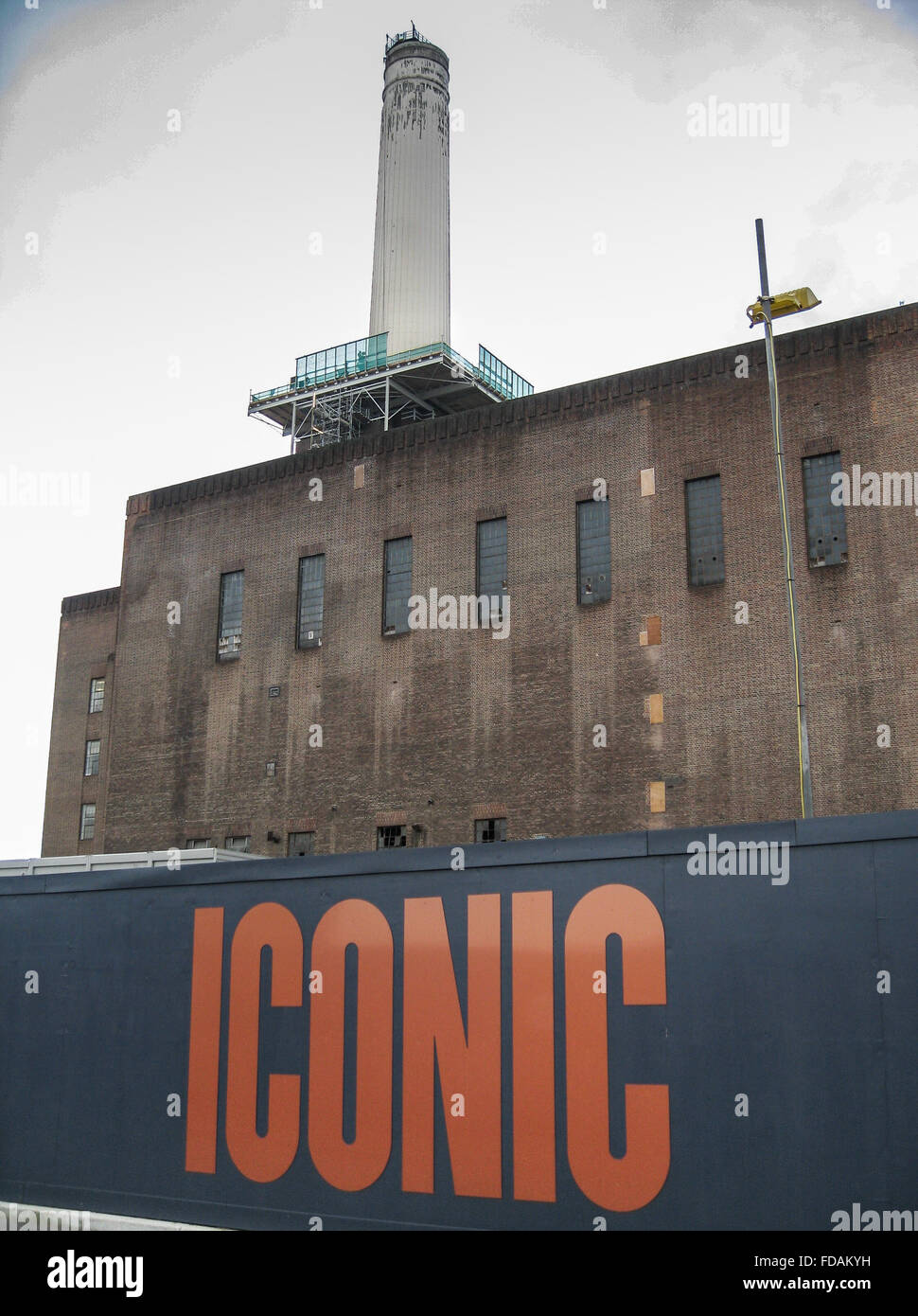 Uno di Battersea Power Station camino con una scheda imbarco con la parola iconico, London REGNO UNITO Foto Stock