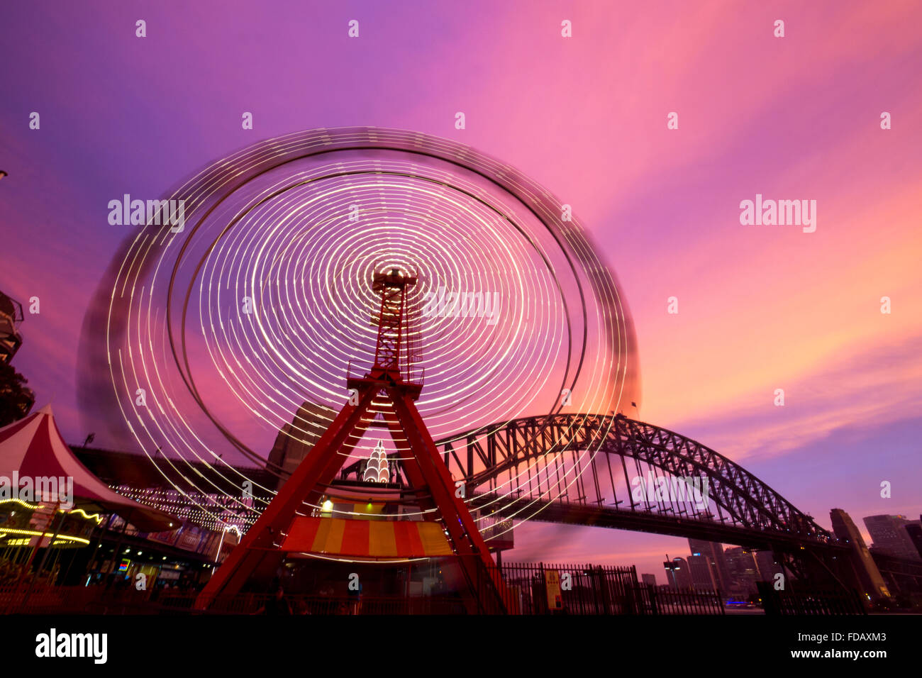 Il Luna Park ruota panoramica Ferris sfocata moto luci di circolazione con Harbour Bridge in background Sydney New South Wales NSW Australia Foto Stock