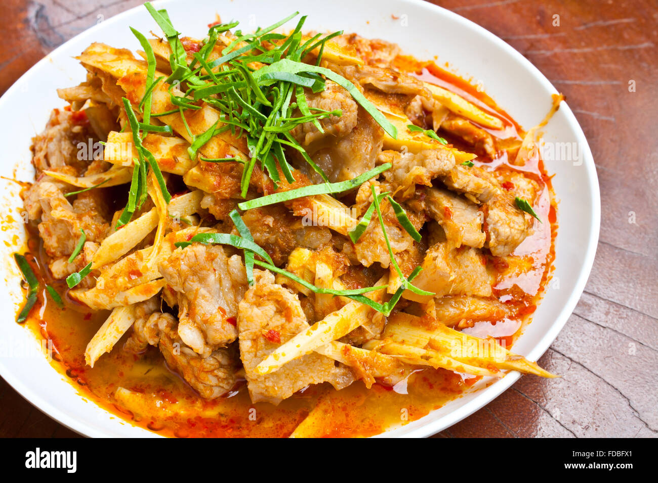 Mescolare la carne di maiale fritto ventre rosso con pasta di curry e germogli di bambù Foto Stock
