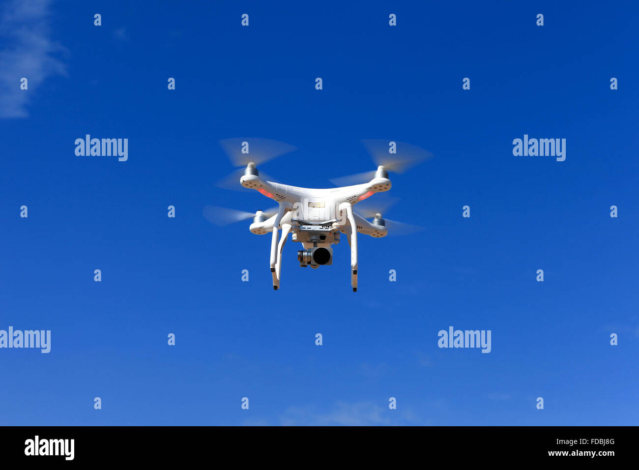 Telecomando bianco drone controllata dotato di videocamera ad alta risoluzione in bilico a metà in aria Foto Stock