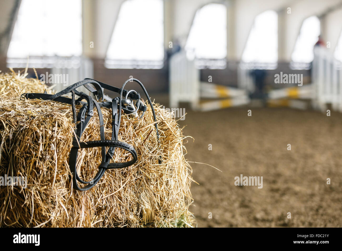 Attrezzatura per cavalli giacente su un fresco di mattoni di fieno su un maneggio Foto Stock