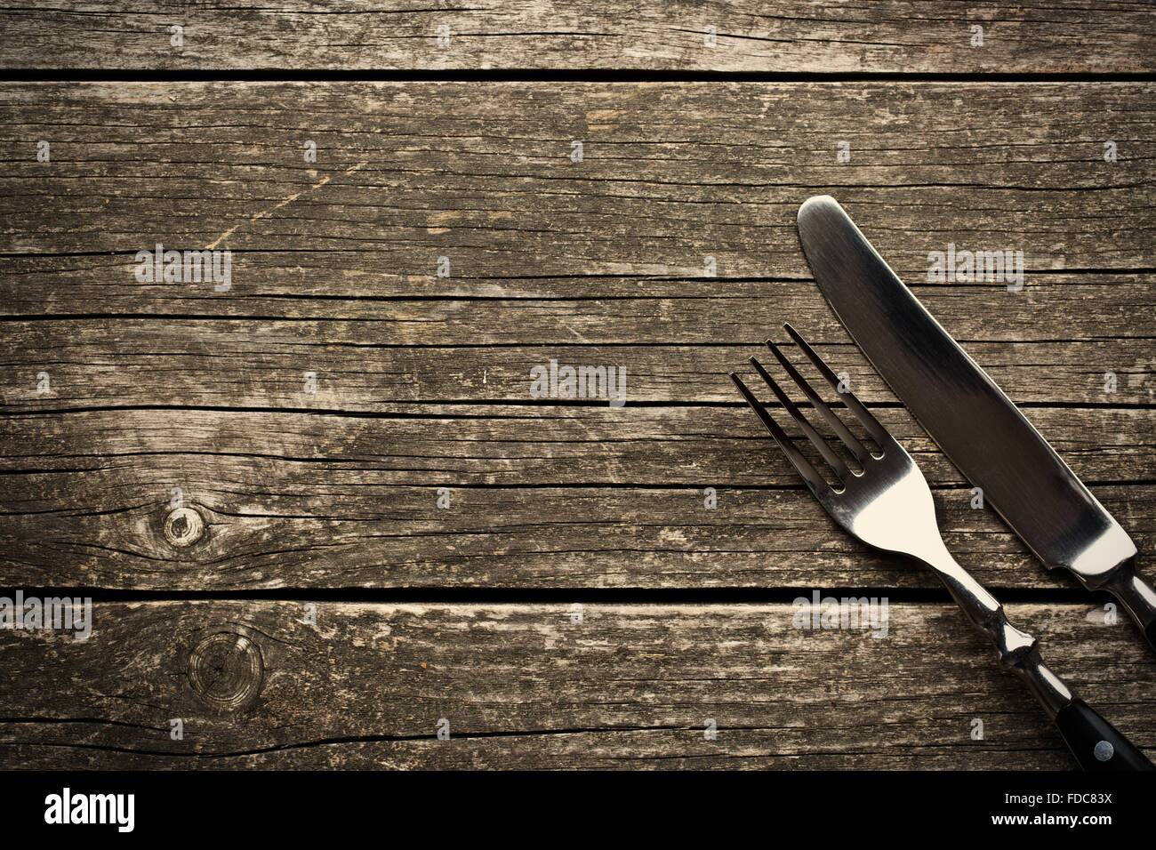 La forchetta e coltello sul vecchio tavolo in legno Foto Stock
