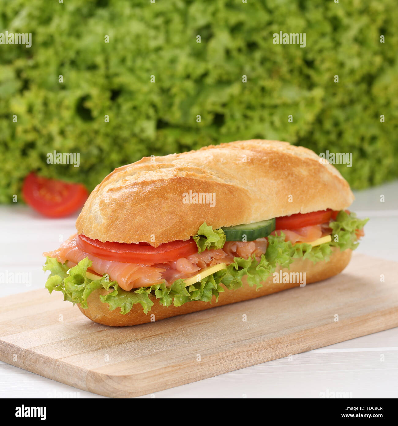 Mangiare sano sub deli sandwich baguette con salmone pesce, formaggio, pomodori e lattuga Foto Stock