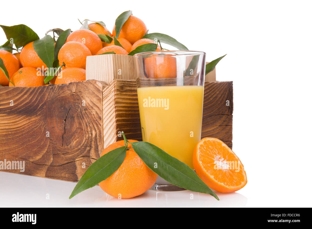 Succo di frutta fresco e mature, di mandarini con foglie verdi in casse di legno. Organici di mandarini freschi, sani mangiando frutta. Foto Stock