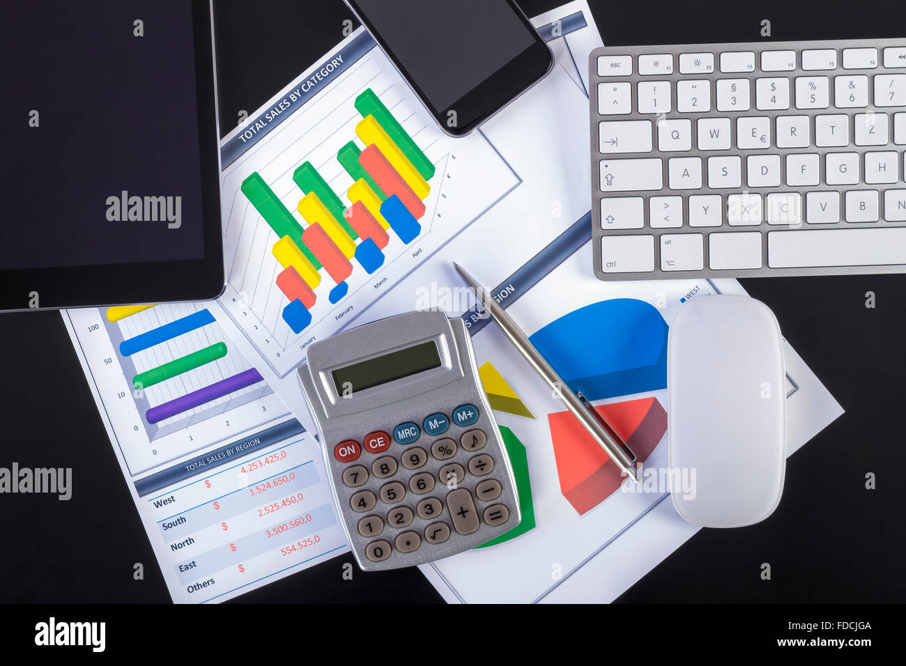 Ambiente di lavoro moderno con tavoletta digitale, penna, tastiera, mouse, smartphone e la carta che mostra grafici e schema numeri sul tavolo. Foto Stock