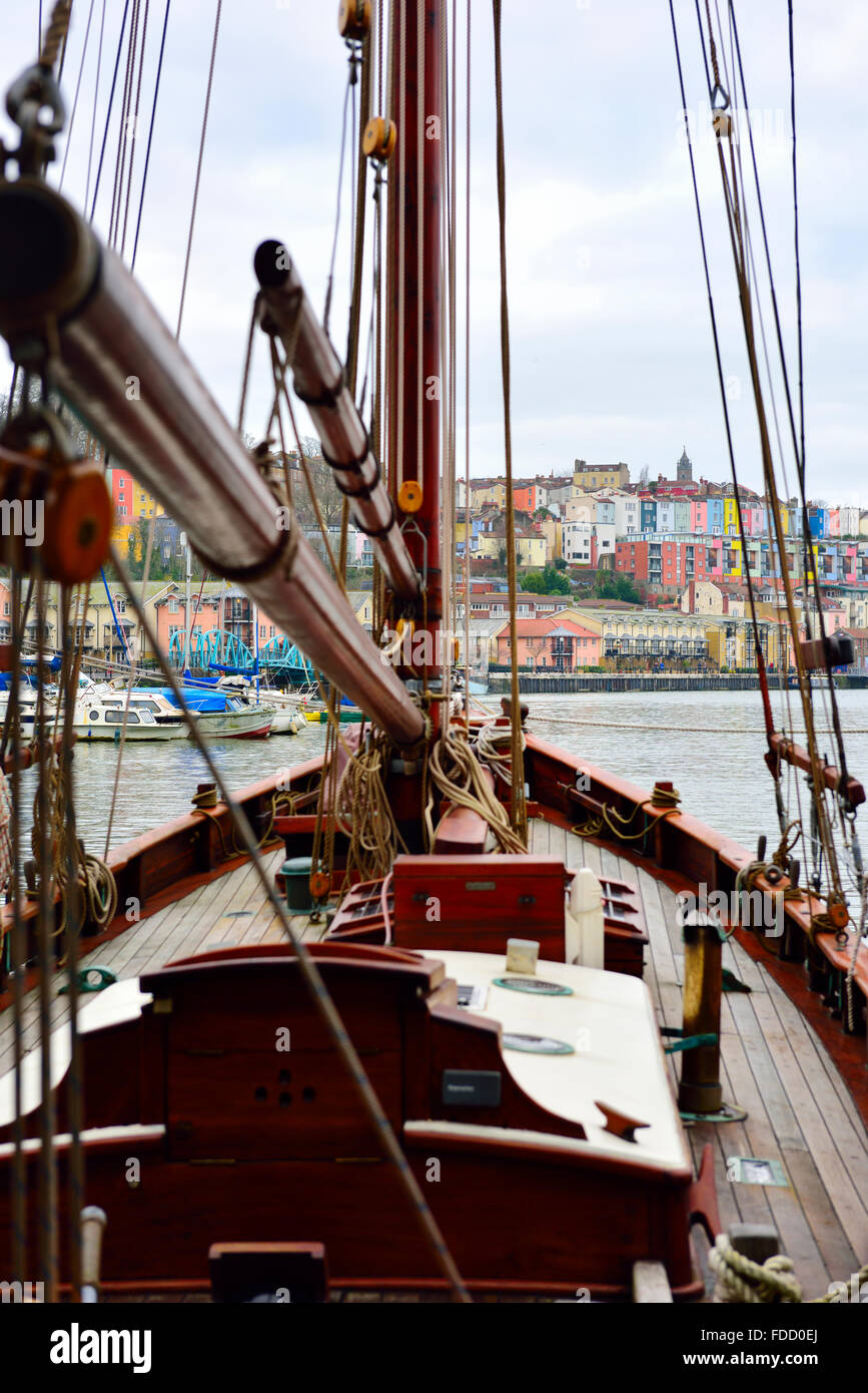 Guardando attraverso manovre di yacht a vela in Bristol Floating Harbour di case colorate in legno di Clifton, Inghilterra Foto Stock