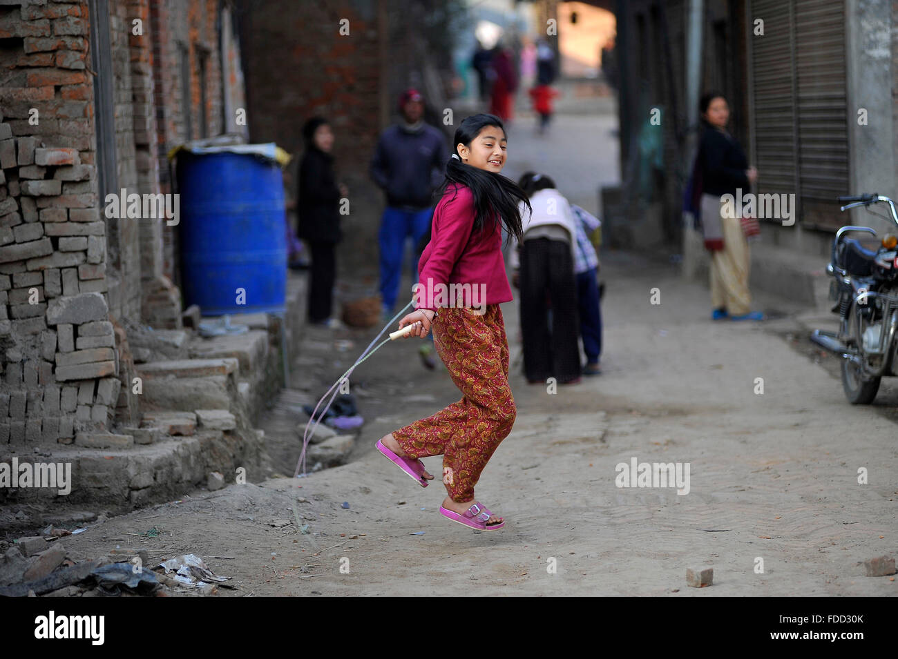 Kathmandu, Nepal. 30 gen, 2016. Un bambino gioca salto con la corda insieme con i suoi amici (non visibile in figura) nella sua città natale in Bhaktapur, Nepal. Bhaktapur elencato come un sito del Patrimonio Culturale Mondiale dell UNESCO per la sua ricca cultura, templi e il legno, il metallo e la pietra opere d'arte. © Narayan Maharjan/Pacific Press/Alamy Live News Foto Stock