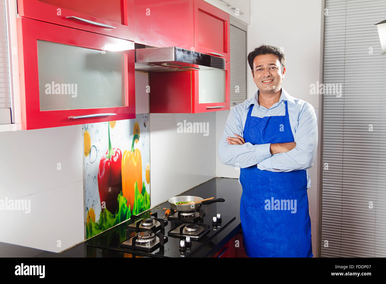1 uomo adulto con le braccia incrociate in piedi casa marito Cucina Cucina Foto Stock