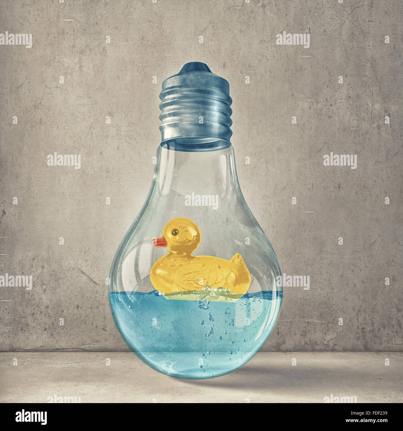 Il vetro della lampadina della luce di colore giallo e di gomma all'interno del giocattolo su sfondo blu Foto Stock