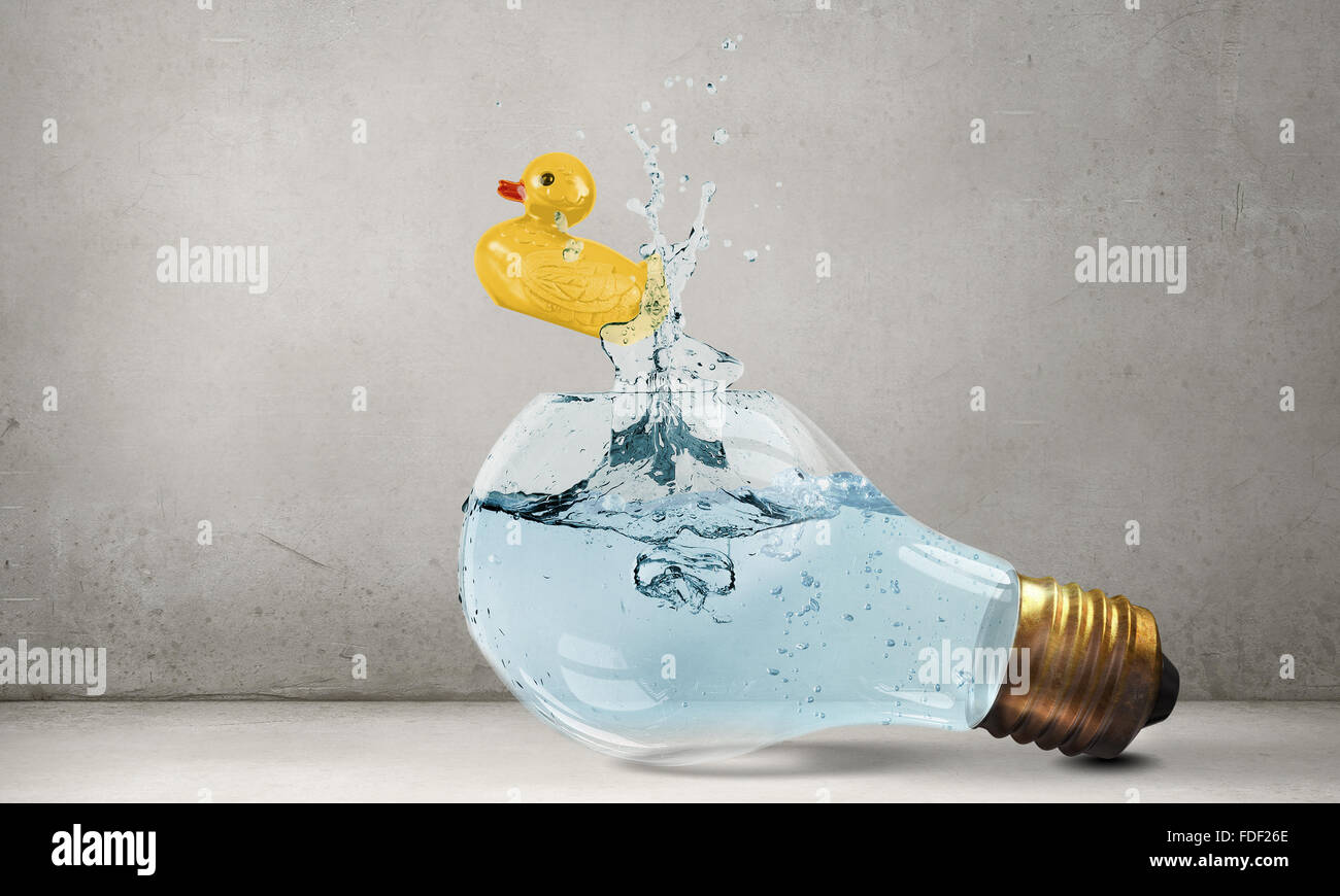 Il vetro della lampadina della luce di colore giallo e di gomma all'interno del giocattolo su sfondo blu Foto Stock