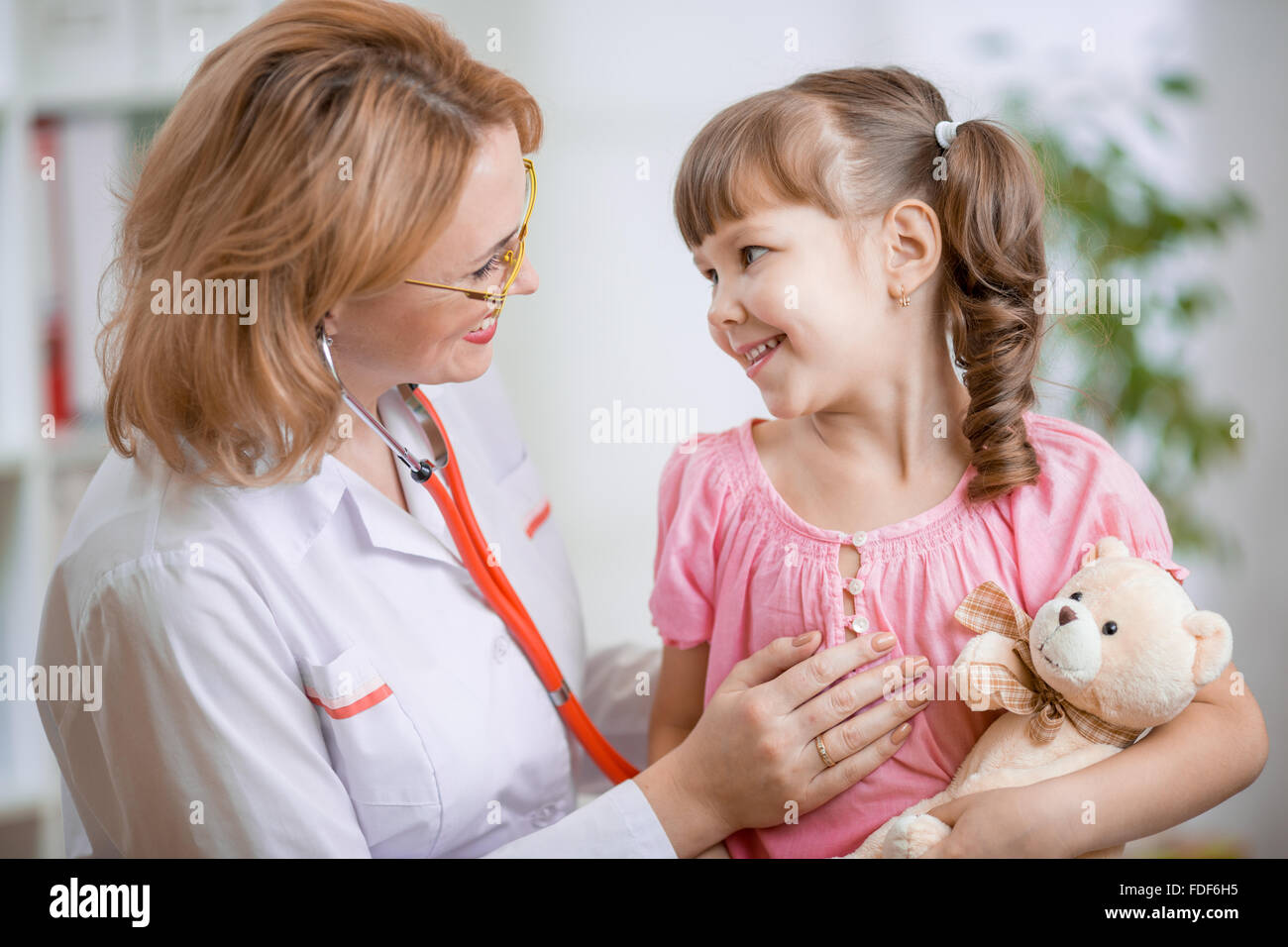 Pediatra parla positivamente con il bambino Foto Stock