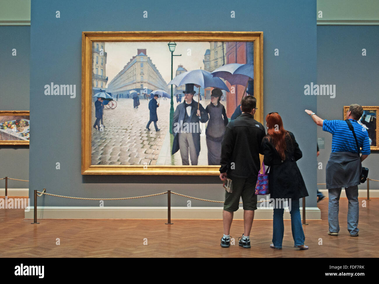 Chicago, Illinois, Stati Uniti d'America: guardando alla pittura ad olio Paris Street Rainy day dall'artista Gustave Caillebotte in una sala dell'Art Institute of Chicago Foto Stock