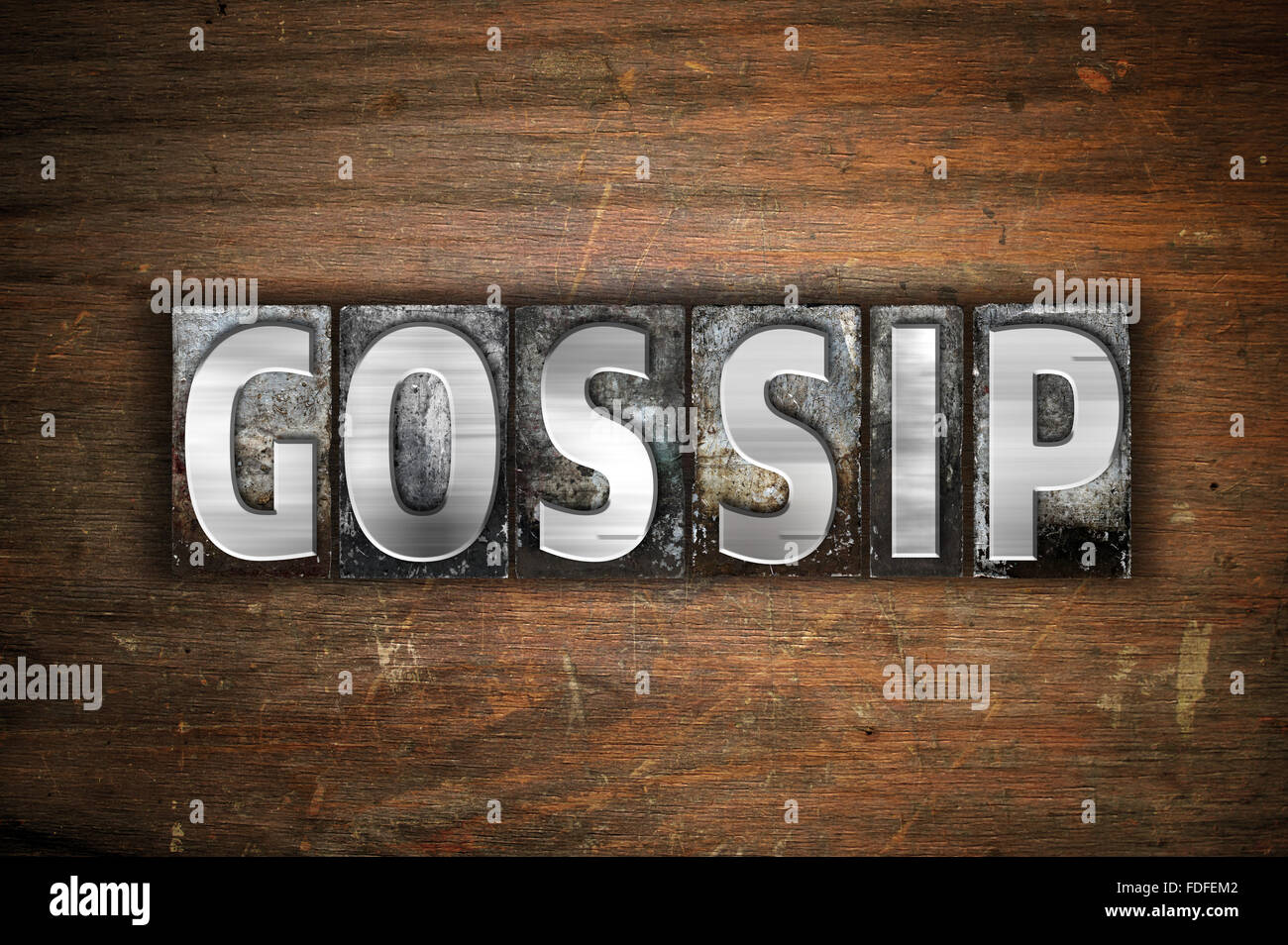 La parola "Gossip" scritto in metallo vintage tipo di stampa in rilievo su un vecchio sfondo di legno. Foto Stock