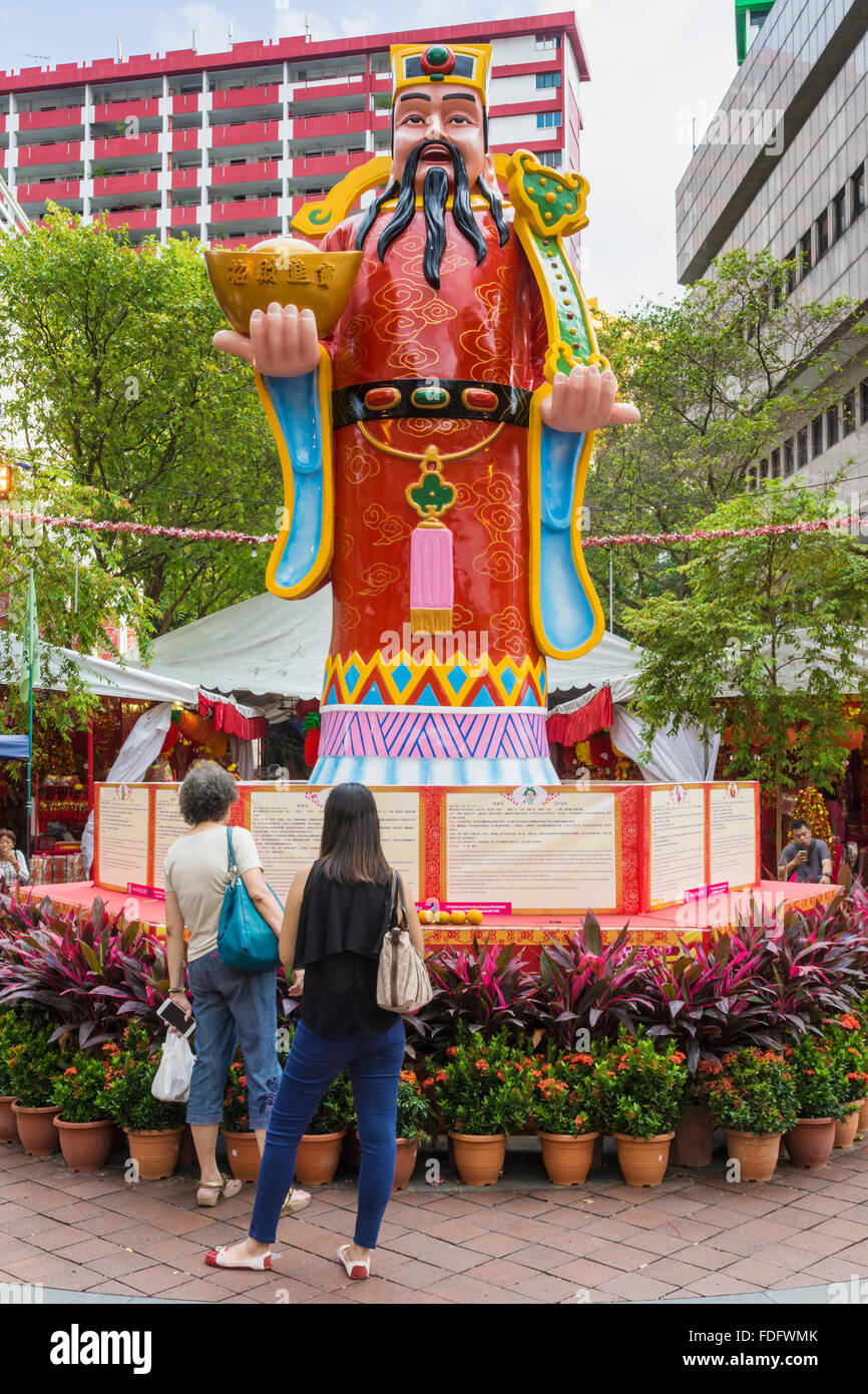 La gente che legge le previsioni su un cinese Zodiaco decorazione a Waterloo St per celebrare il capodanno cinese della scimmia, Singapore Foto Stock