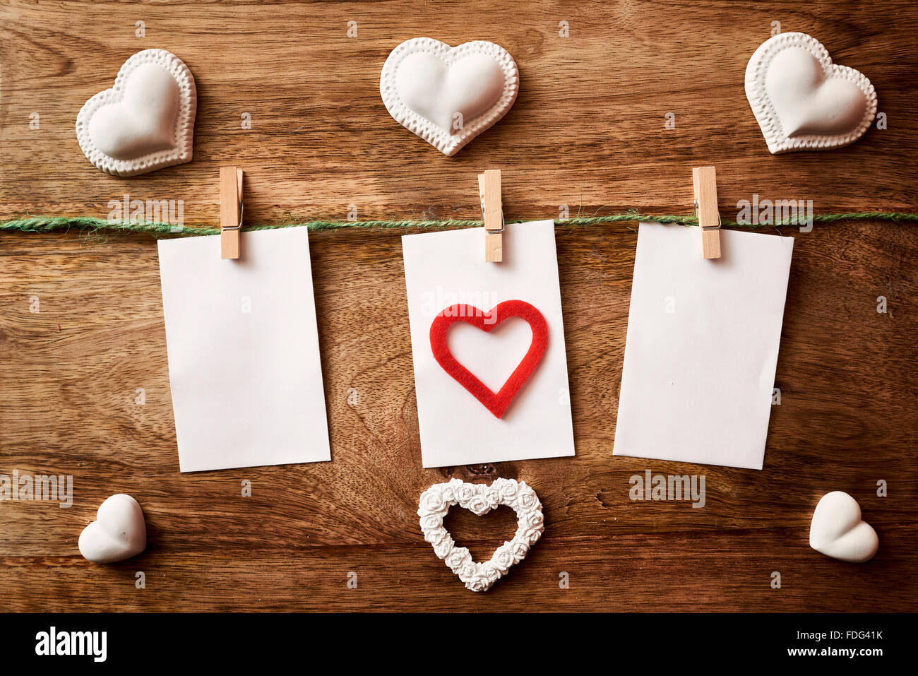 Cavo con tre carta e clothespins su legno con chalk cuore Foto Stock