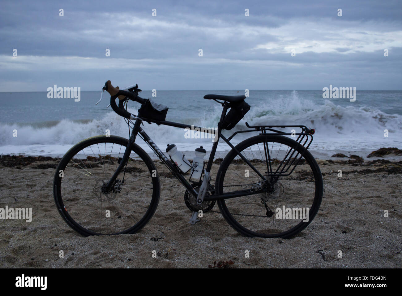 Una touring bike su Gyllyngvase Beach a sunrise Foto Stock