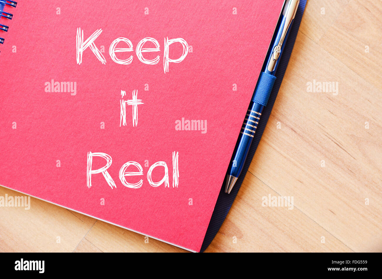 Keep it reale concetto di testo scrivere su notebook con penna Foto Stock