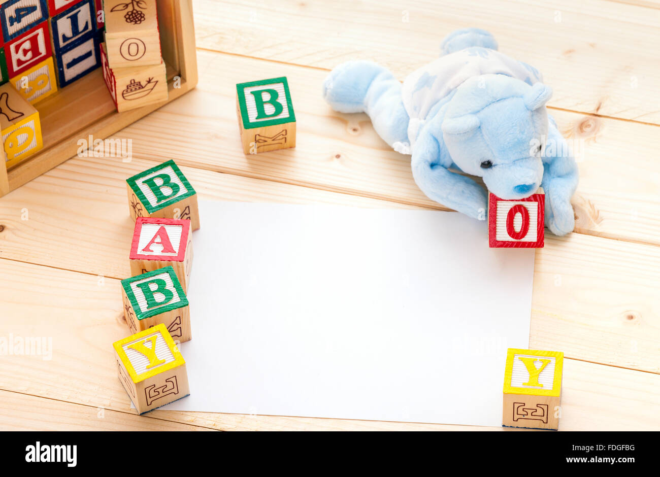 Annuncio di nascita invito un giocattolo blu portano l'ortografia delle parole baby boy con il giocattolo di legno su blocchi di legno di pino sullo sfondo del pavimento Foto Stock