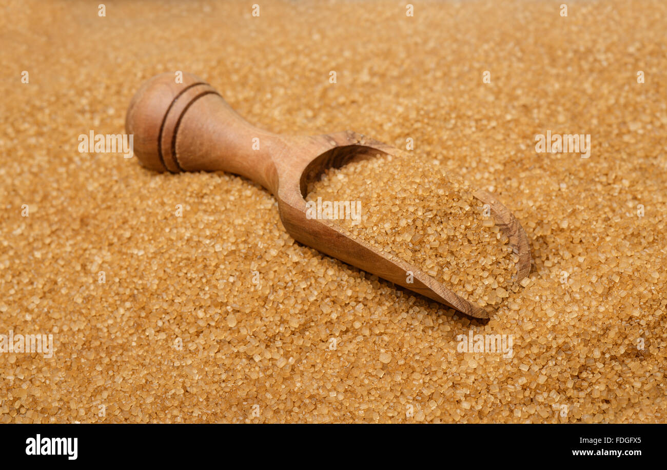 Cucchiaio di legno su di zucchero di canna Foto Stock