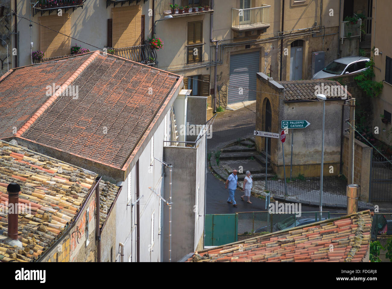 Coppia senior Italia, in vista di una coppia di anziani prendendo un inizio serata a piedi attraverso le strade di Enna in Sicilia. Foto Stock