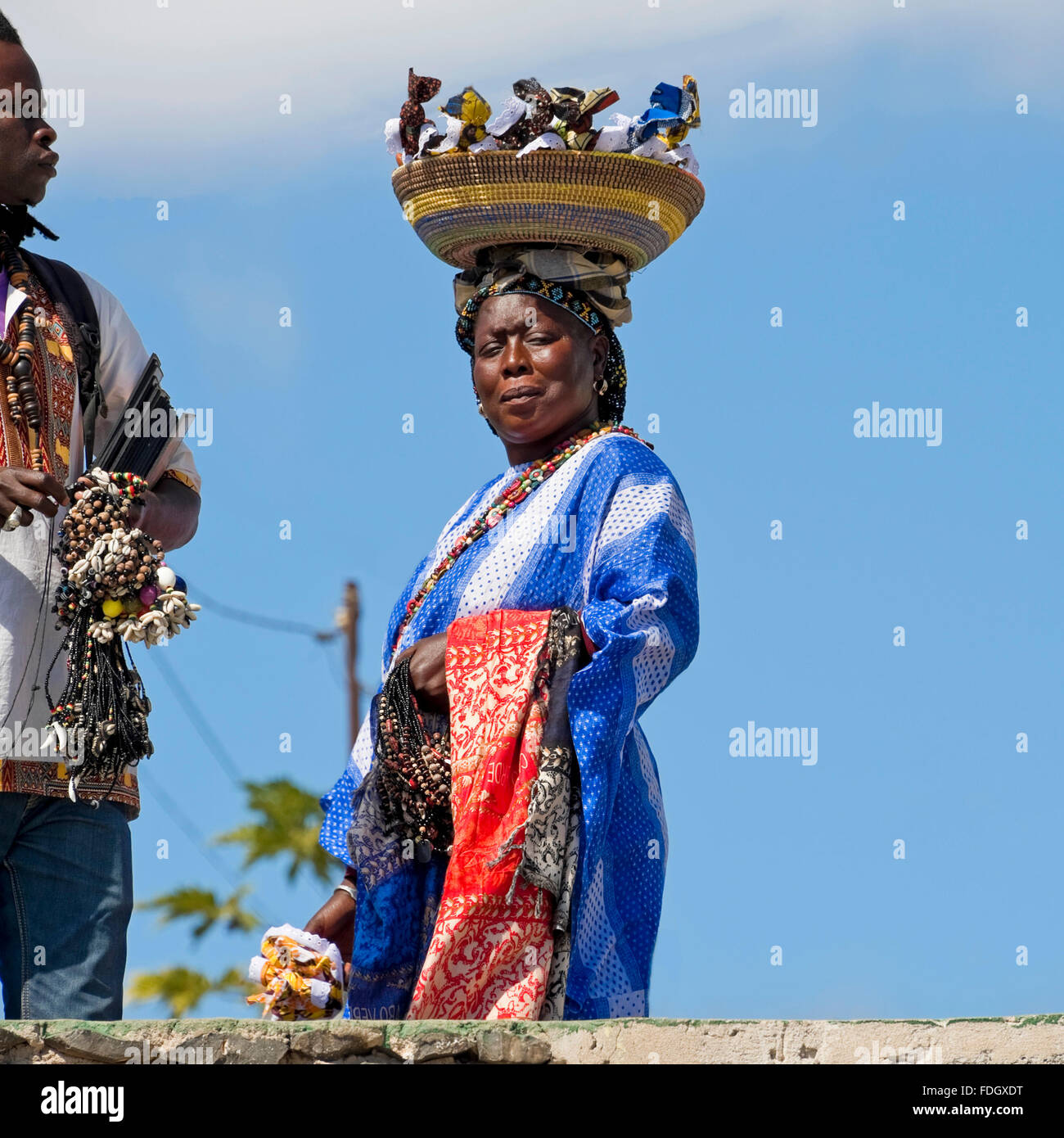 Square ritratto di un locale del Capo Verde donna che vende souvenir da un cestello equilibrato sul suo capo a Capo Verde. Foto Stock
