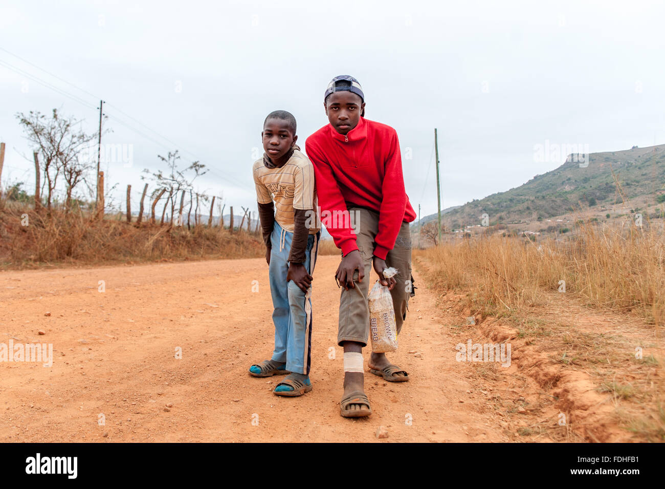 Due giovani ragazzi in piedi in una strada sterrata nella regione Hhohho dello Swaziland, Africa. Foto Stock