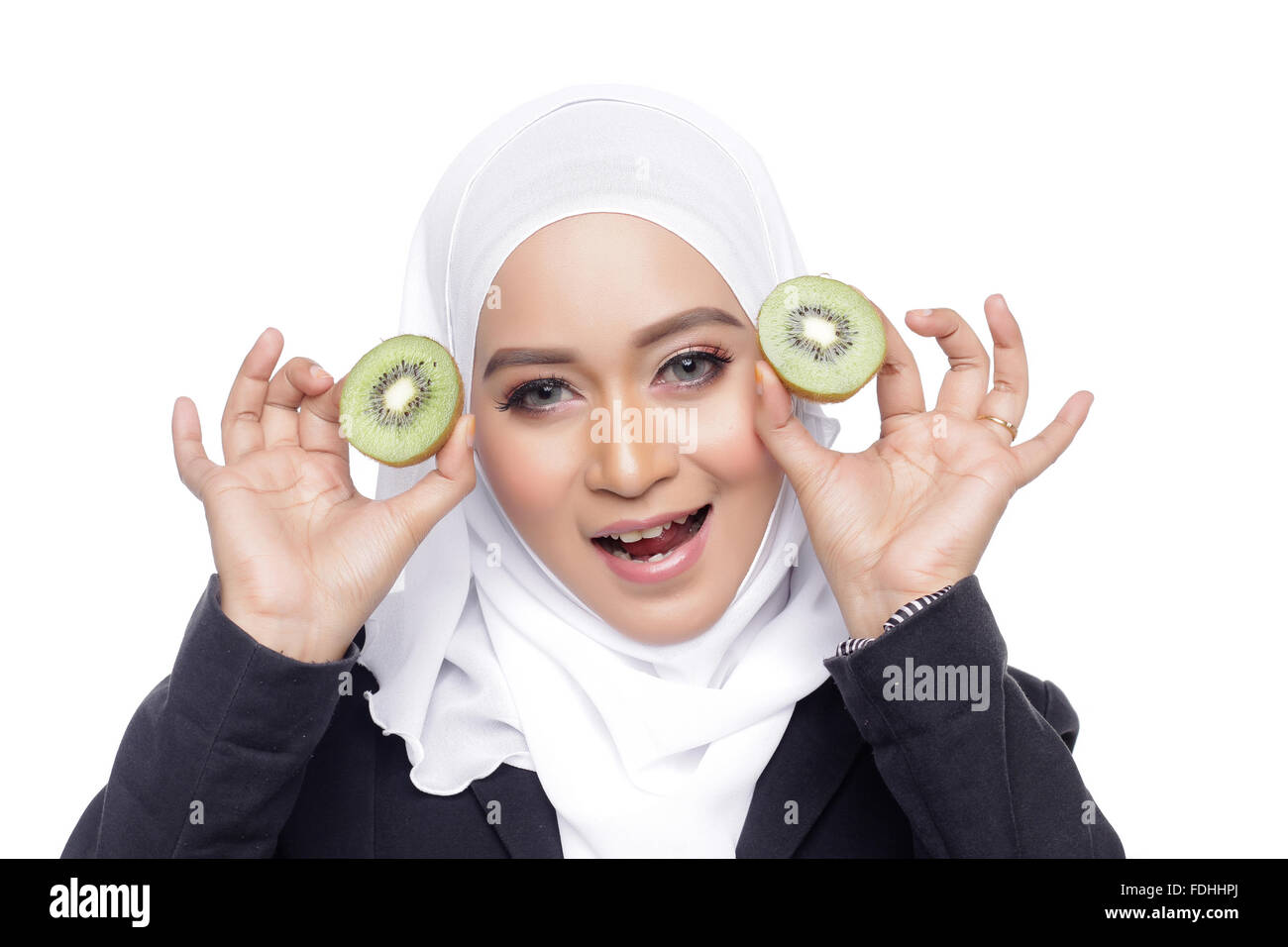 Asian bella donna muslimah mangiar sano kiwi sfondo bianco Foto Stock