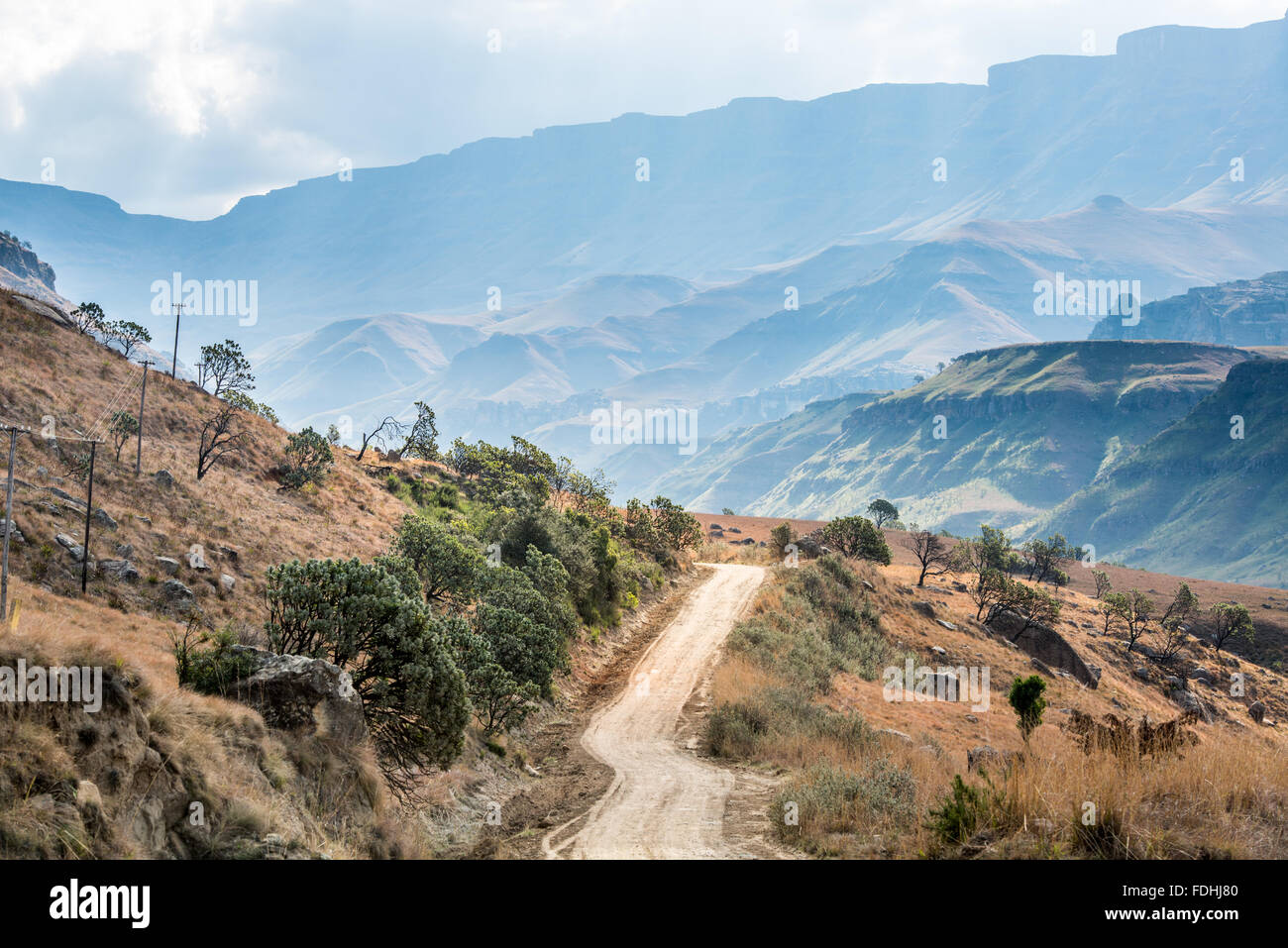 Vuoto su strada sterrata avvolgimento attraverso Sani Pass, tra il Sudafrica e il Lesotho. Foto Stock