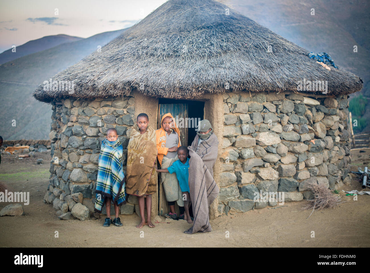I bambini piccoli in piedi la porta al loro villaggio capanna in Lesotho, Africa Foto Stock