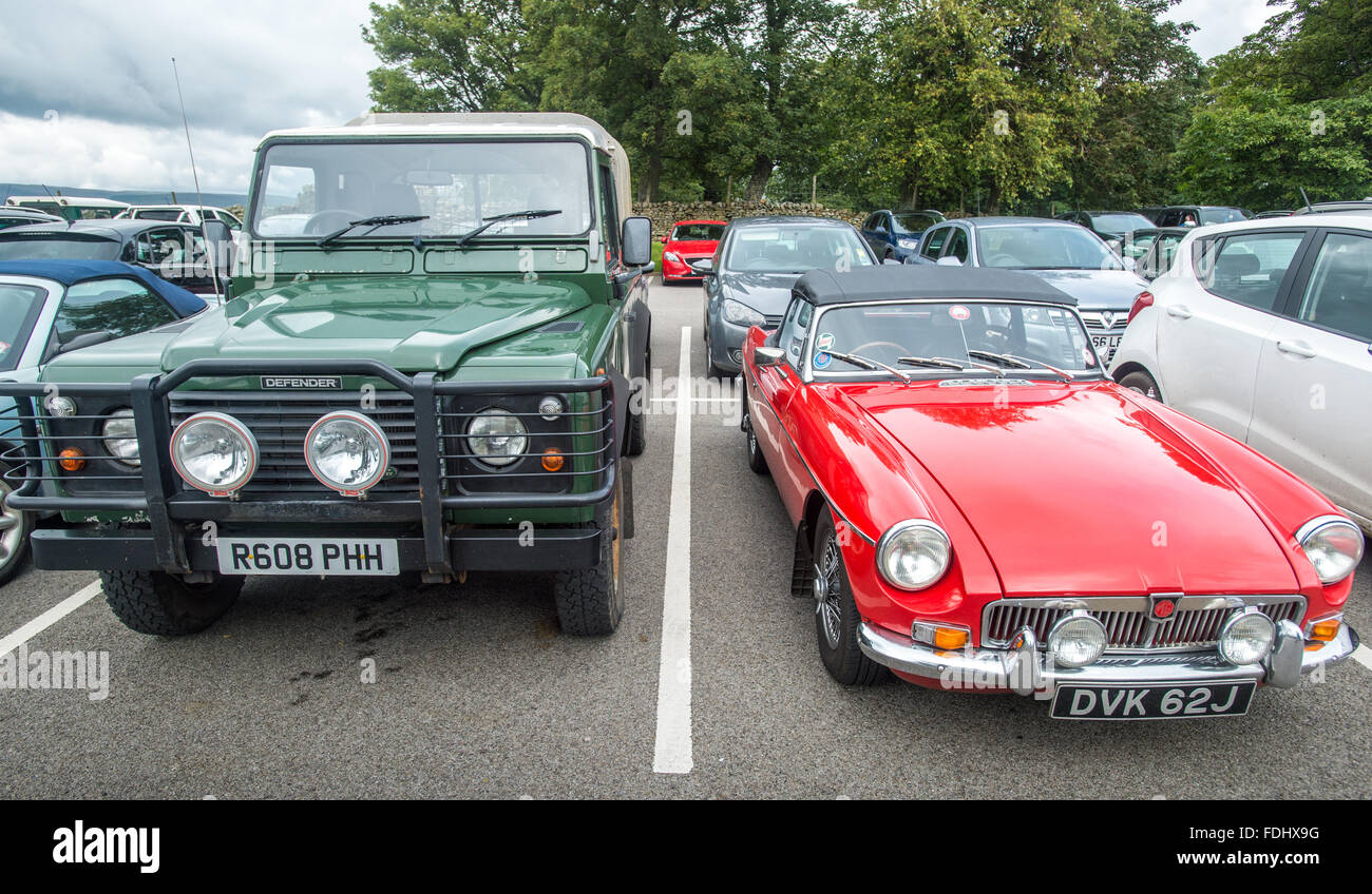 Landrover Defender e paraurti cromato MGB in un parcheggio nello Yorkshire, Inghilterra, Regno Unito Foto Stock