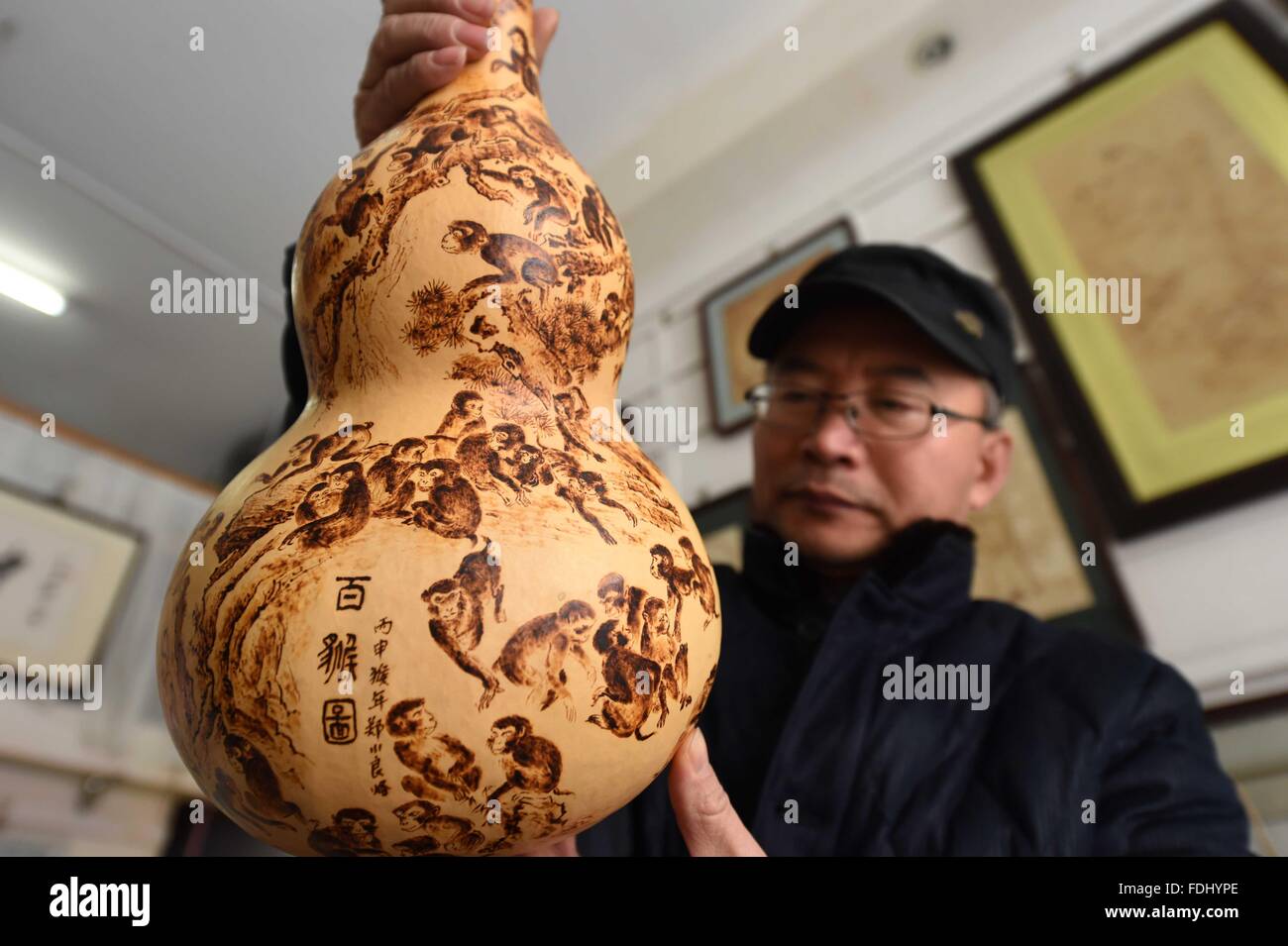 Hefei, cinese della provincia di Anhui. Il 1° febbraio 2016. Zheng Xiaoliang mostra il suo dipinto pyrograph su un calabash a Hefei, a est della capitale cinese della provincia di Anhui, 1 febbraio 2016. Del Pyrography su calabash è stato elencato come uno dei provinciali del patrimonio immateriale. Come un ereditiere del mestiere, Zheng Xiaoliang ha attirato oltre 100 scimmie su un calabash con un'altezza di 50 centimetri e una larghezza di 23 centimetri per esprimere i migliori auguri per il prossimo nuovo anno lunare cinese, l'anno della scimmia che inizia dal 8 febbraio di quest'anno. © Xie Chen/Xinhua/Alamy Live News Foto Stock