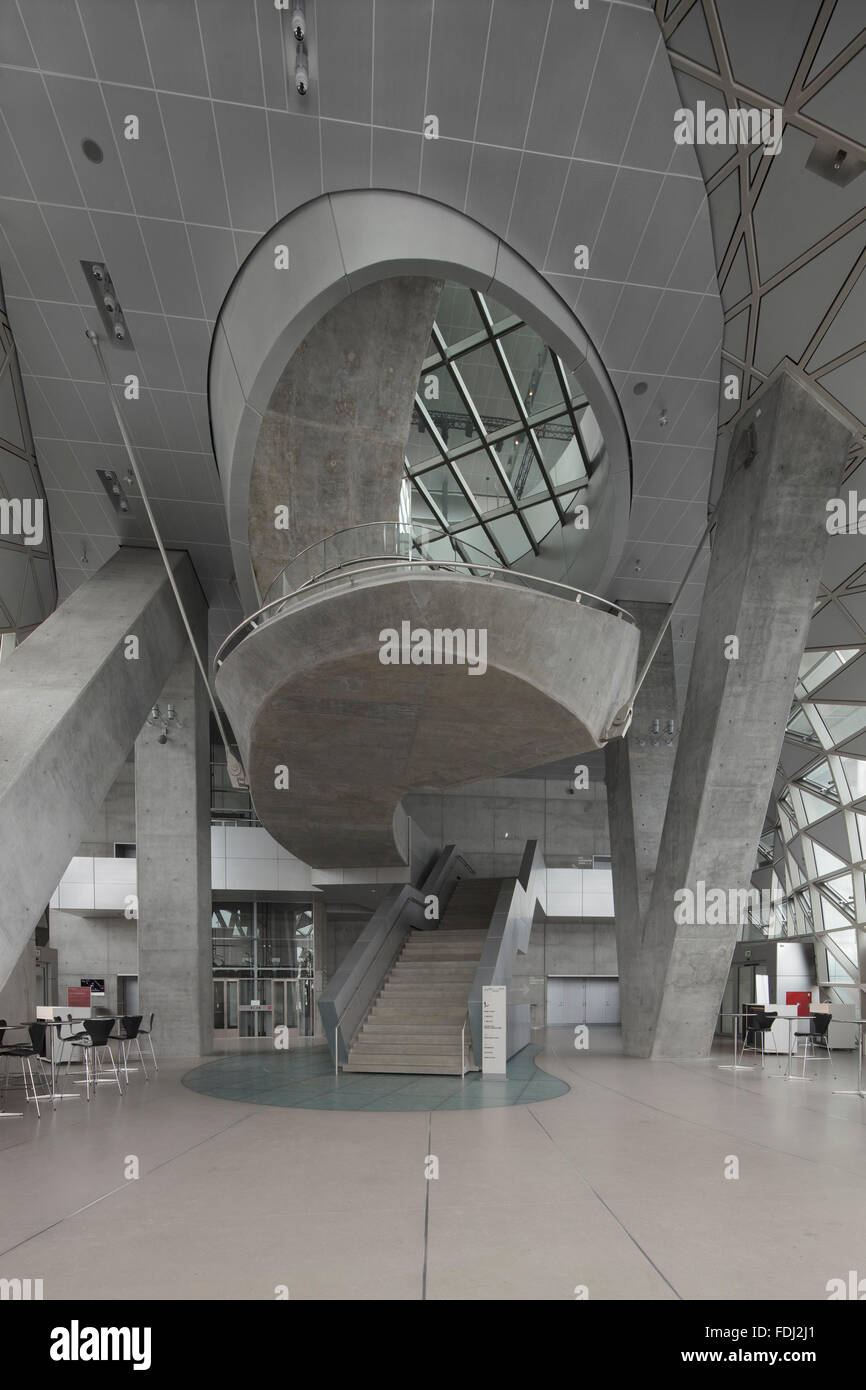 Foyer con calcestruzzo scalinata a spirale e colonne inclinate. Musikkens Hus Aalborg, Aalborg, Danimarca. Architetto: Coop Himmelb(l)au, Foto Stock