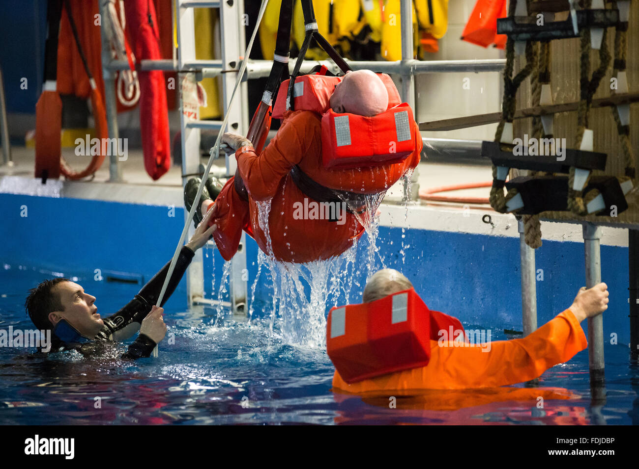 Un uomo è winched dall'acqua di mare durante la formazione di sopravvivenza. Foto Stock