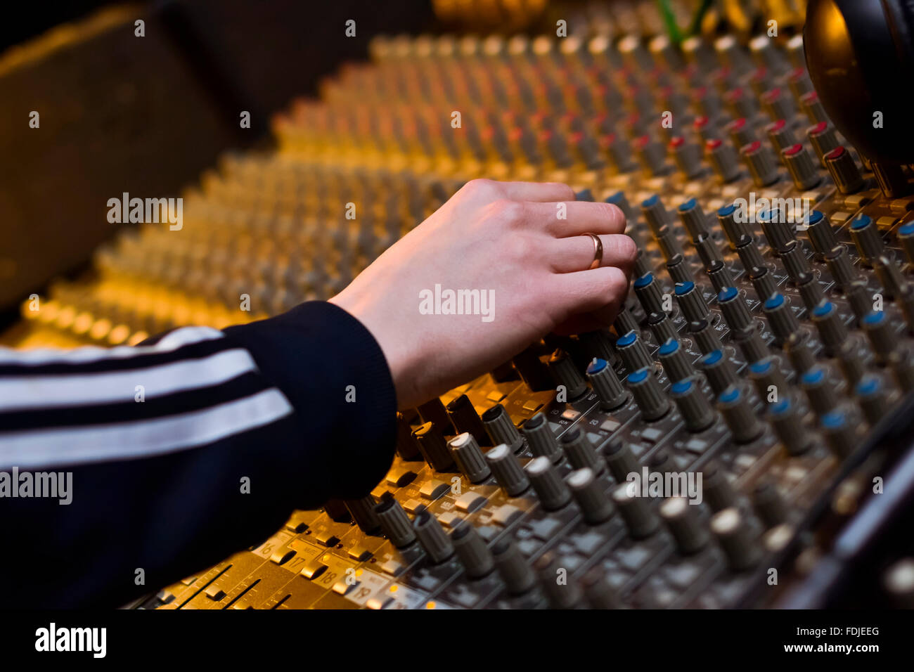 Le mani di un DJ mentre si lavora su professional audio mixer musicale, attrezzature Digital Voice Recorder Foto Stock