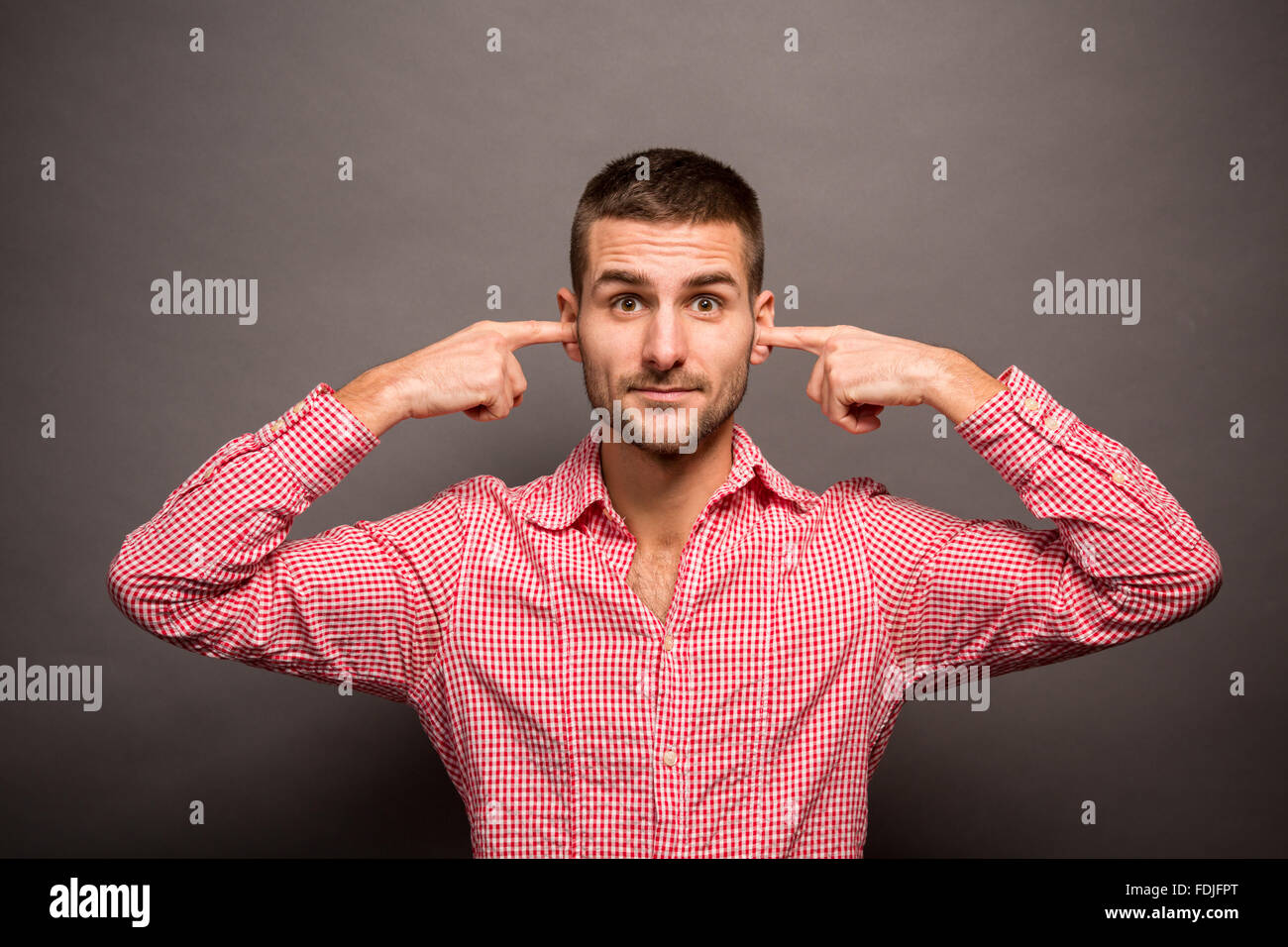 Uomo che copre le sue orecchie Foto Stock