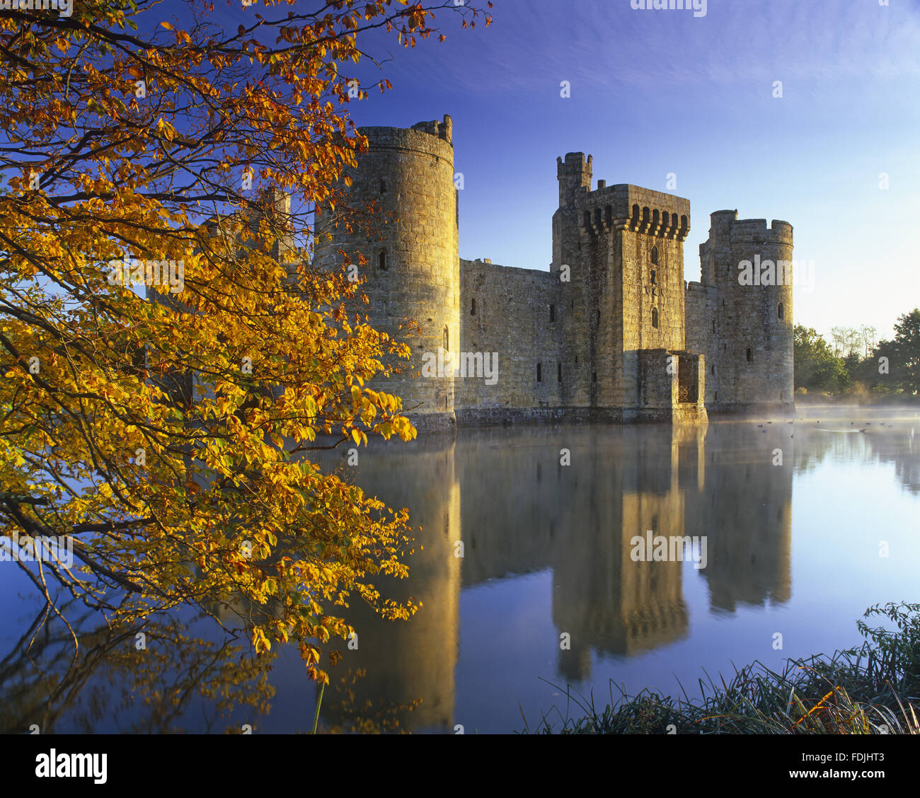 Una leggera foschia si alza dal fossato quasi all alba del XIV secolo Castello Bodiam, East Sussex. Foto Stock