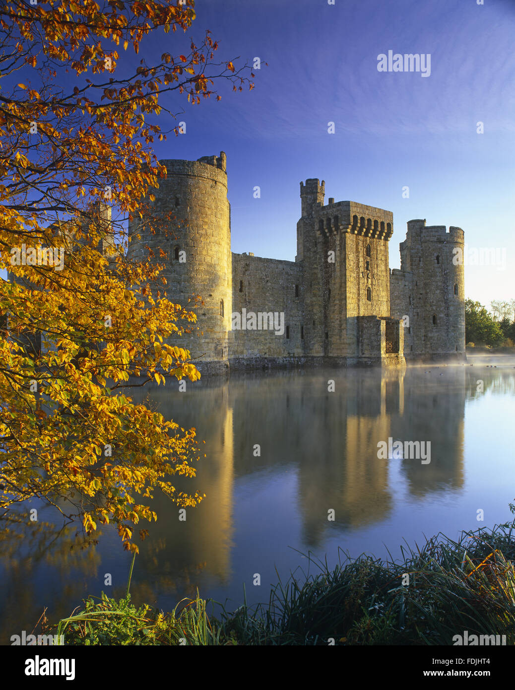 Una leggera foschia si alza dal fossato quasi all alba del XIV secolo Castello Bodiam, East Sussex. Foto Stock