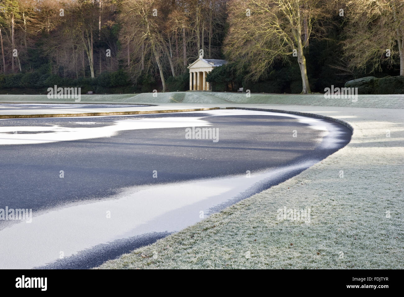 Veduta invernale del tempio di pietà visto oltre il Half-Moon stagno, a Studley Royal acqua da giardino, North Yorkshire. I giardini sono stati creati nel 1716 da John Aislabie e proseguito da suo figlio Guglielmo nel seguito del XVIII secolo. Foto Stock