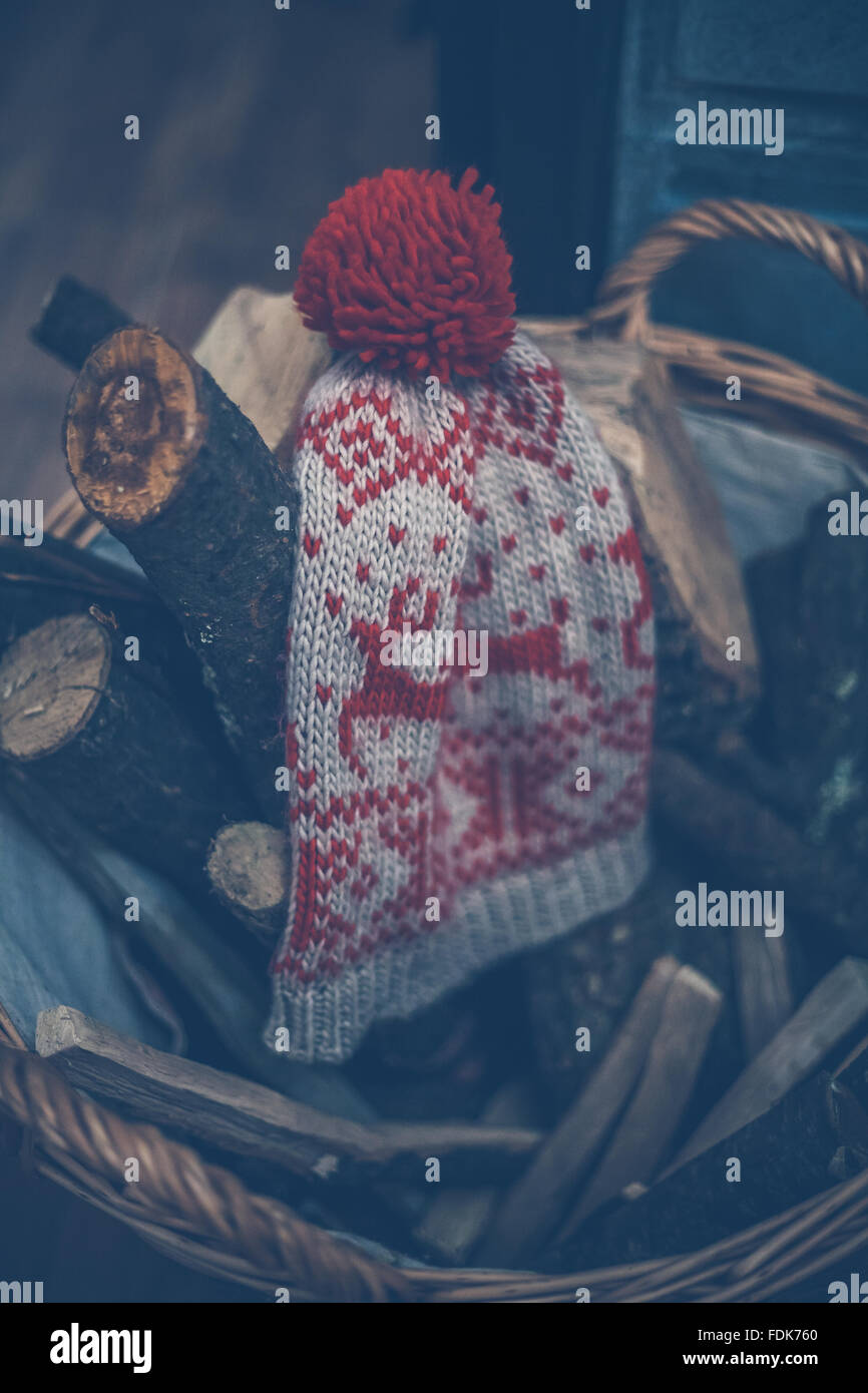 Un wooly hat su un cesto di legna da ardere Foto Stock