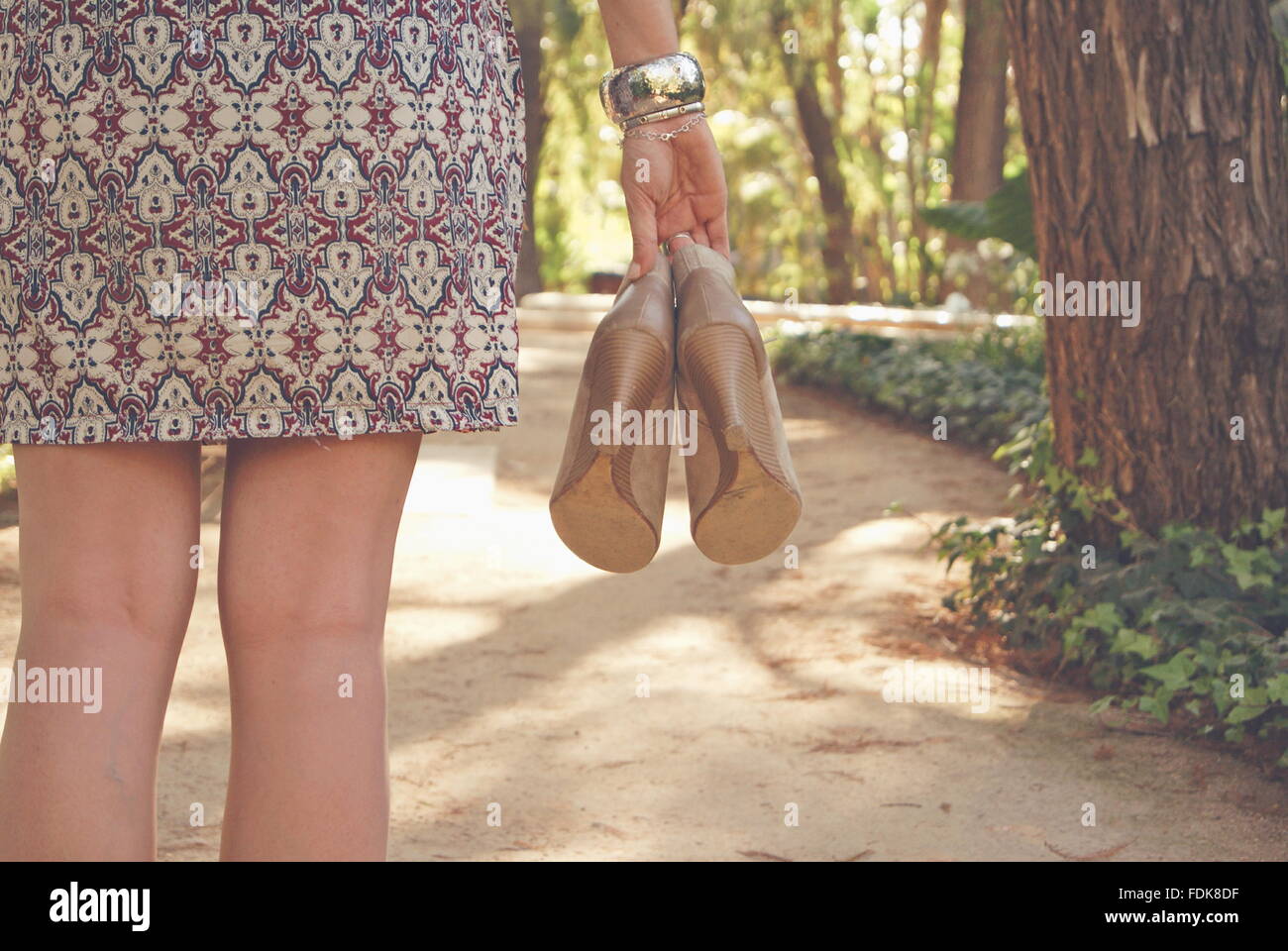 Vista posteriore di una donna holding paio di scarpe Foto Stock
