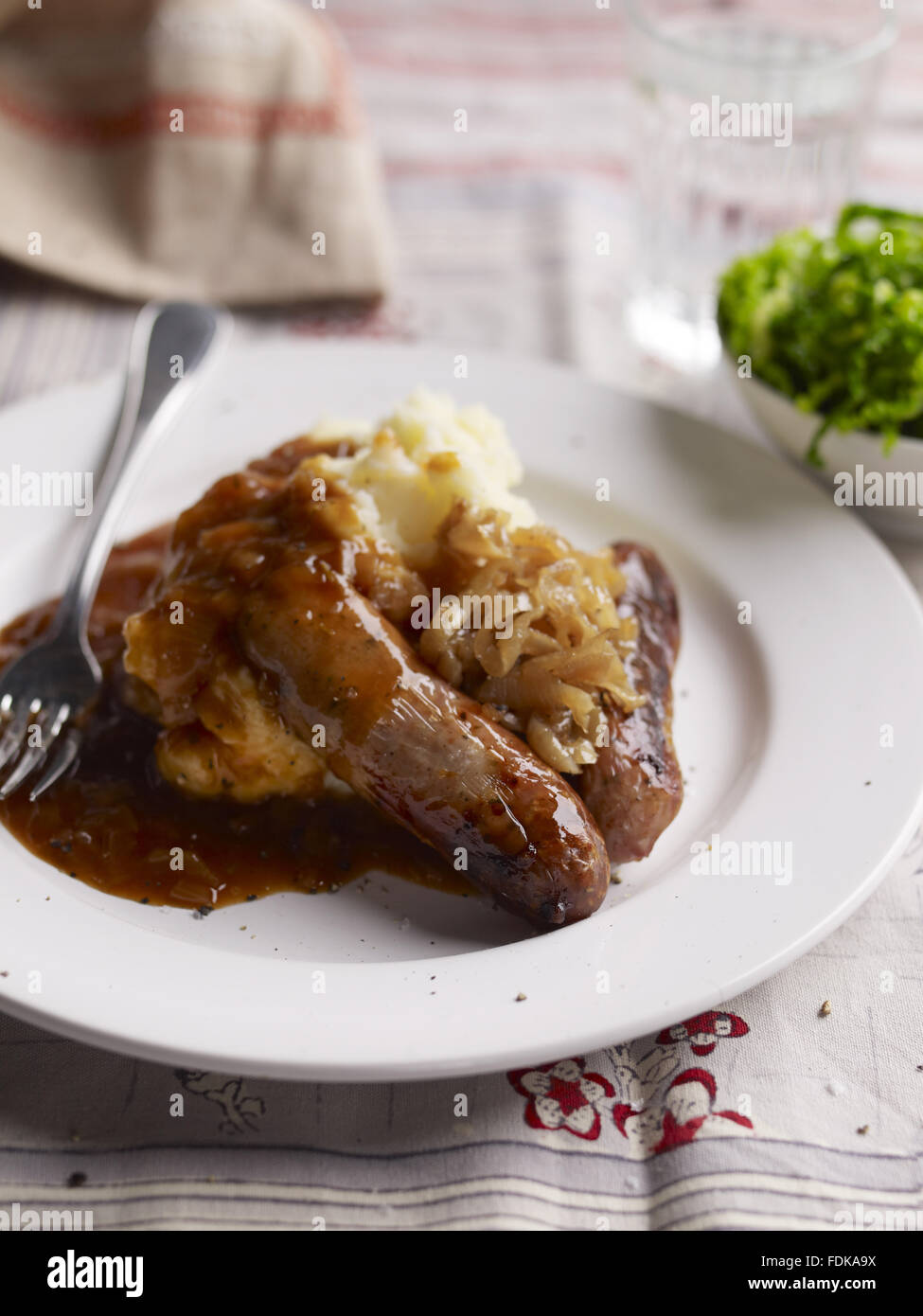 Salsicce e schiacciarle con cipolle e salsa, uno dei piatti tradizionali serviti in National Trust ristoranti. Foto Stock