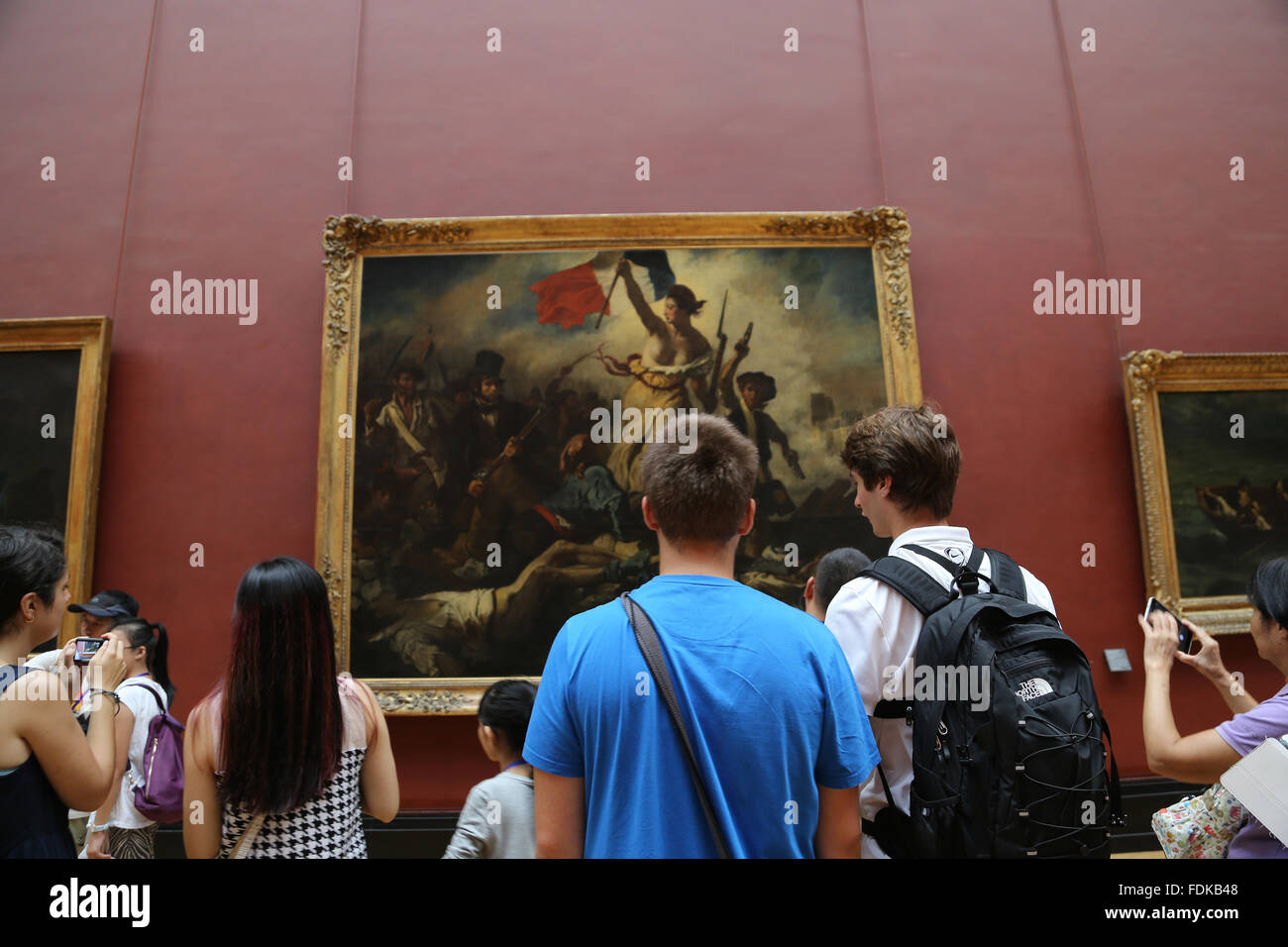 Tourist all'interno del museo del Louvre. La libertà di guidare il popolo, 1831. Da Eugene Delacroix. Parigi. Foto Stock
