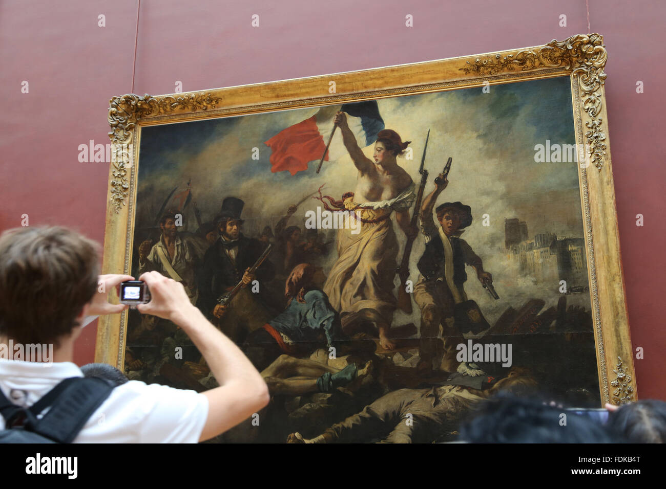 Tourist all'interno del museo del Louvre. La libertà di guidare il popolo, 1831. Da Eugene Delacroix. Parigi. Foto Stock