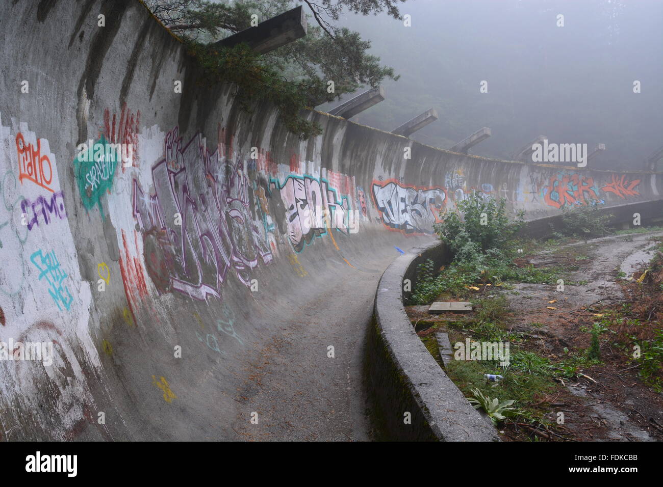 Una curva a metà strada giù per la guerra di bob danneggiato eseguire dal 1984 Sito olimpico si trova abbandonato in montagna sopra Sarajevo. Foto Stock