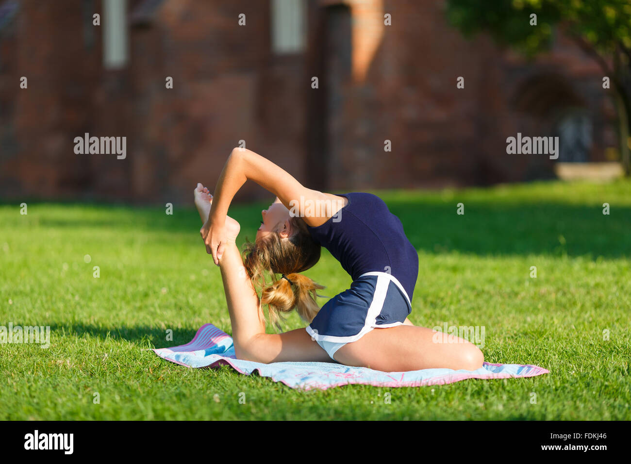 Ragazza giovane e carina facendo esercizi yoga outdoor Foto Stock